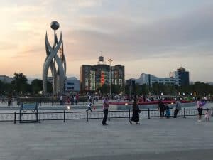 Yanqing Platz in der Stadtmitte bei Sonnenuntergang mit Menschen, welche verschiedene körperliche Aktivitäten ausüben